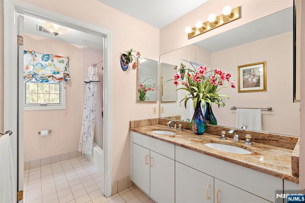 163 Rutherford Road Mahwah, NJ 07430 - Photo 25 of 33 a bathroom with a granite countertop sink a mirror and a shower