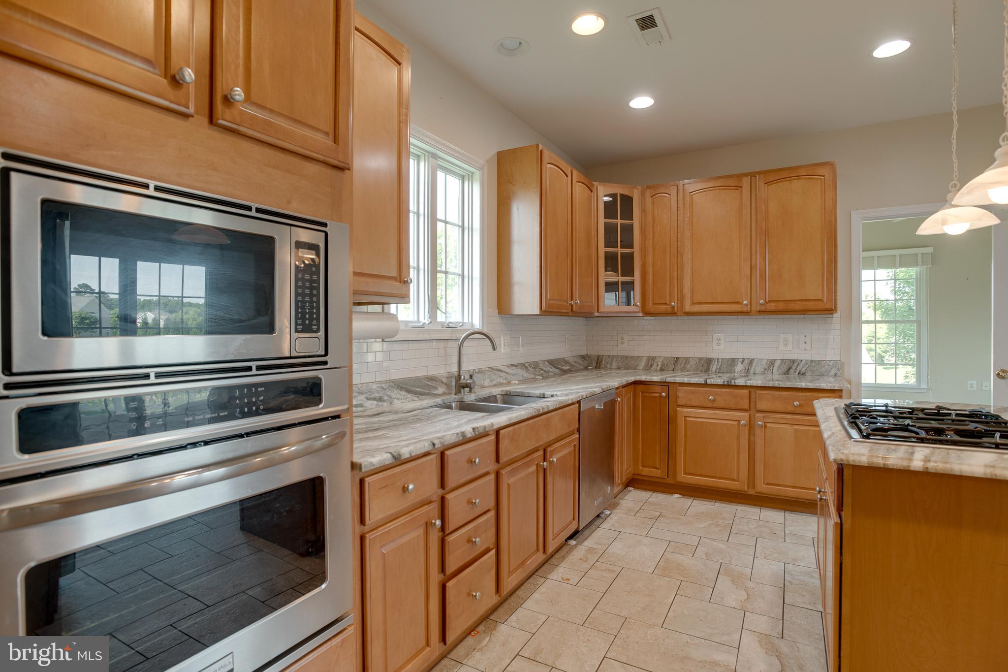 14308 South Hall Court Culpeper, VA 22701 - Photo 15 of 78 a kitchen with stainless steel appliances granite countertop stove microwave and cabinets