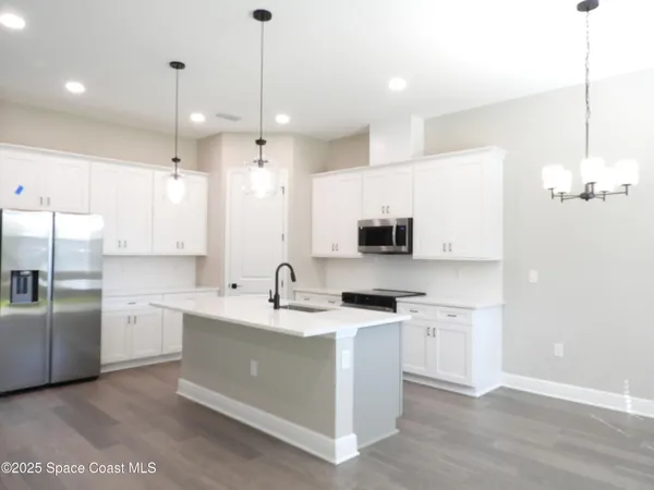 a kitchen with kitchen island white cabinets and stainless steel appliances