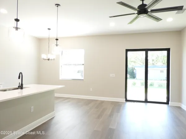 a kitchen with a sink stainless steel appliances a counter space and wooden floor