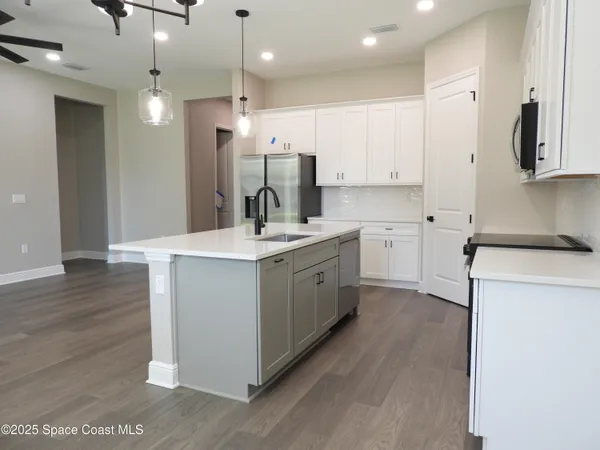 a kitchen with kitchen island a sink appliances and cabinets