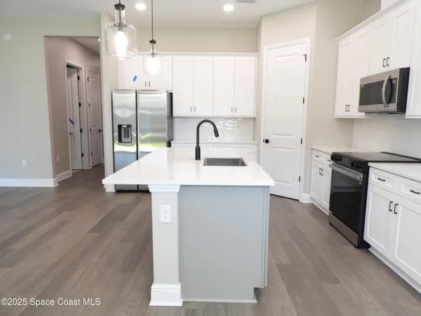 a view of a kitchen with a sink wooden floor and a window