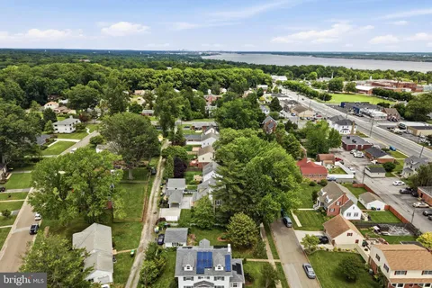 an aerial view of residential houses with outdoor space and trees