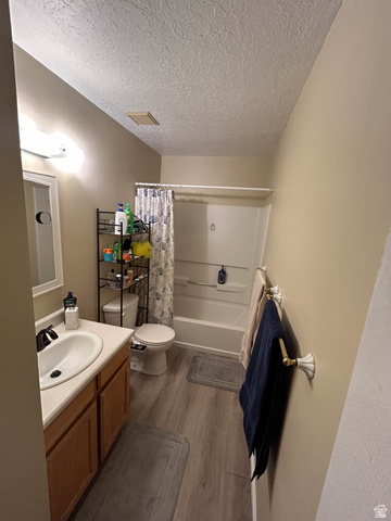 939 South Freedom Boulevard, Unit 13 Provo, UT 84601 - Photo 17 of 26 Full bath with vanity, dark wood-type flooring, shower / bath combo with shower curtain, and a textured ceiling