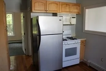 a white refrigerator freezer and a stove sitting inside of a kitchen