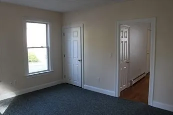 an empty room with windows and closet