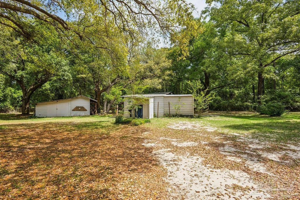 8938 Pioneer Road Holt, FL 32564 - Photo 32 of 44 a house with trees in front of it