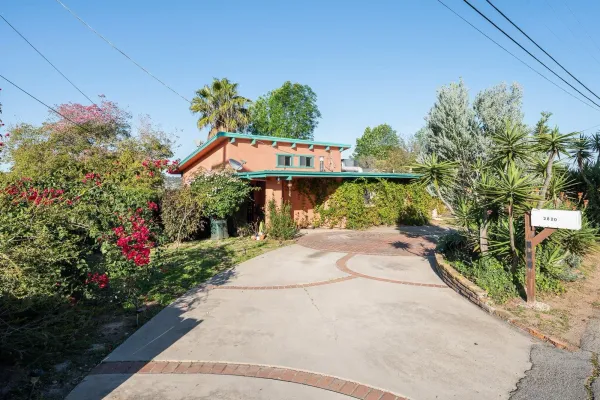 a front view of a house with a yard and a fountain
