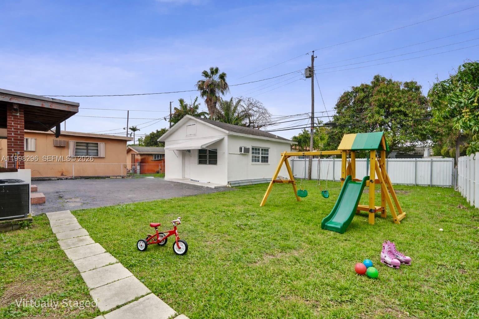 877 West 33rd Street Hialeah, FL 33012 - Photo 13 of 59 a view of backyard with a slide and potted plants