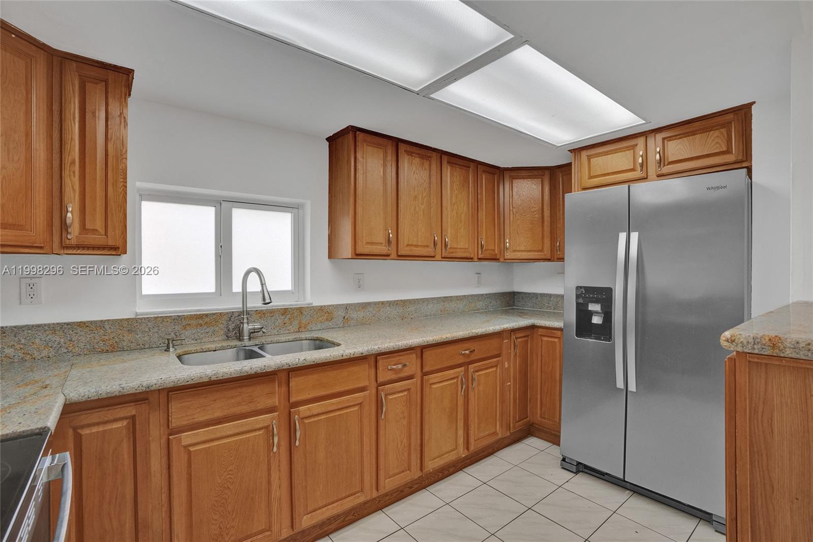 877 West 33rd Street Hialeah, FL 33012 - Photo 24 of 59 a kitchen with a sink refrigerator and cabinets