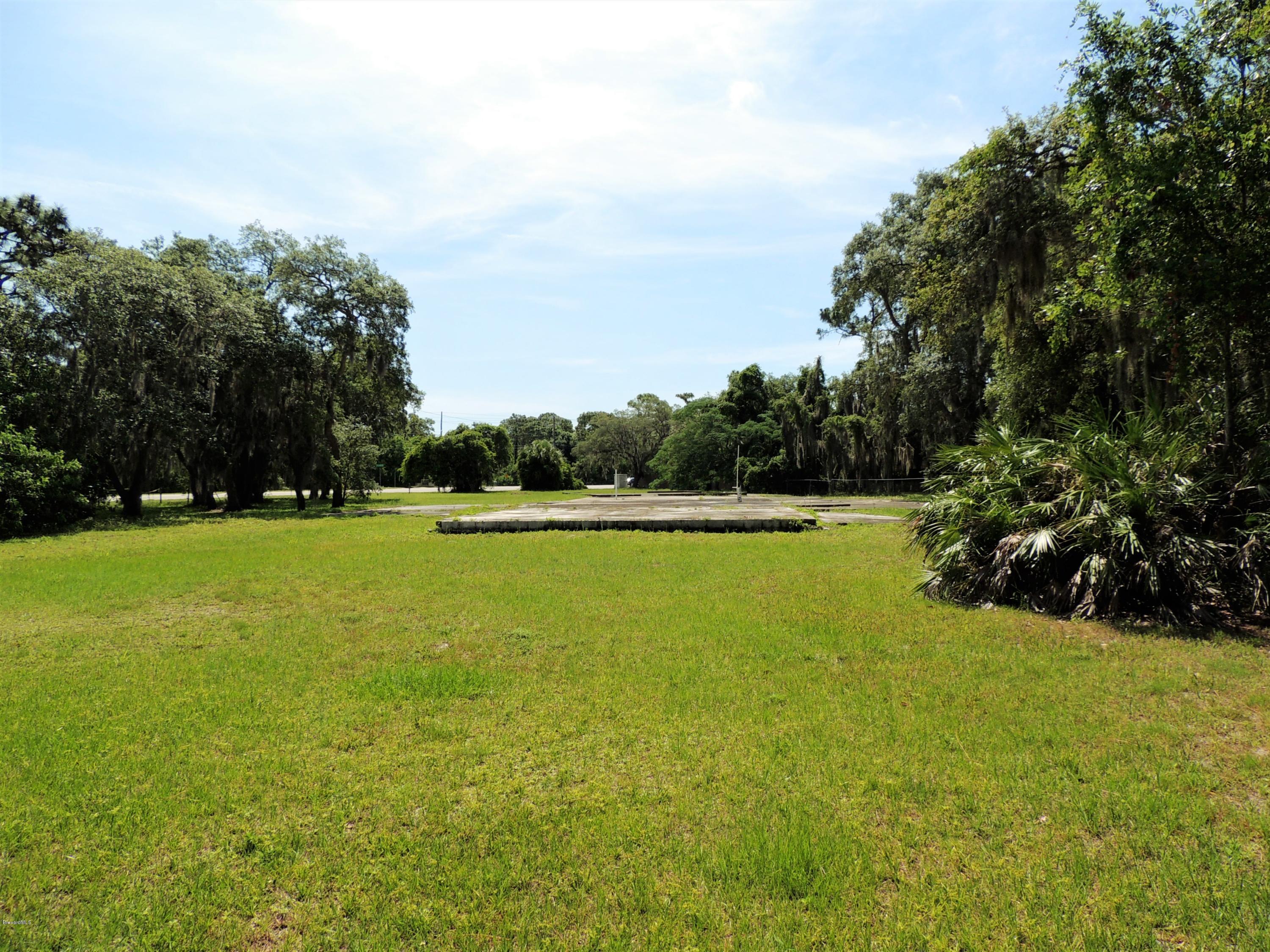 3570 Turtle Mound Road Melbourne, FL 32934 - Photo 2 of 19 a view of a green field with wooden fence
