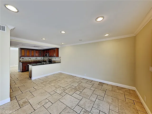 a view of a kitchen with a sink and an empty room