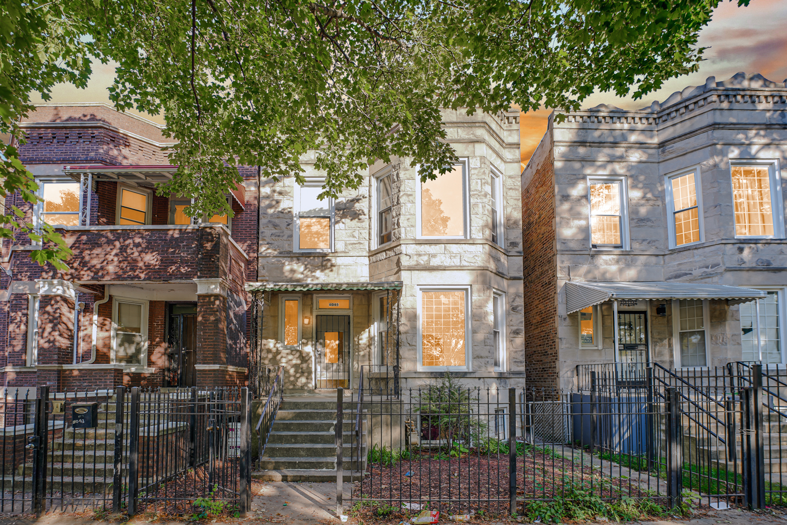 a front view of a building with glass windows and plants