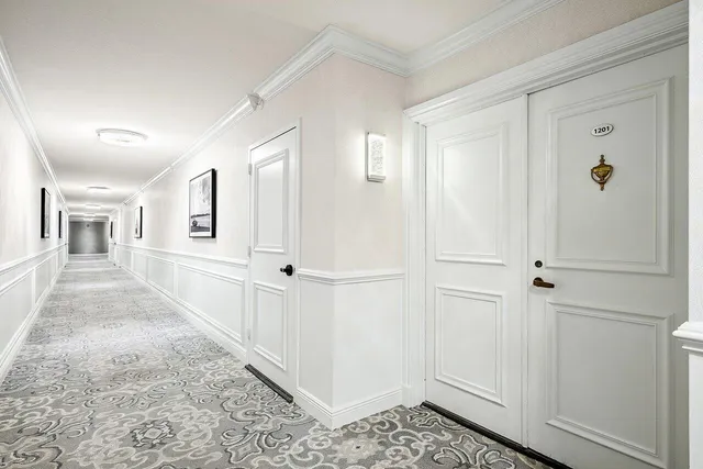 a view of a hallway with wooden floor and closet