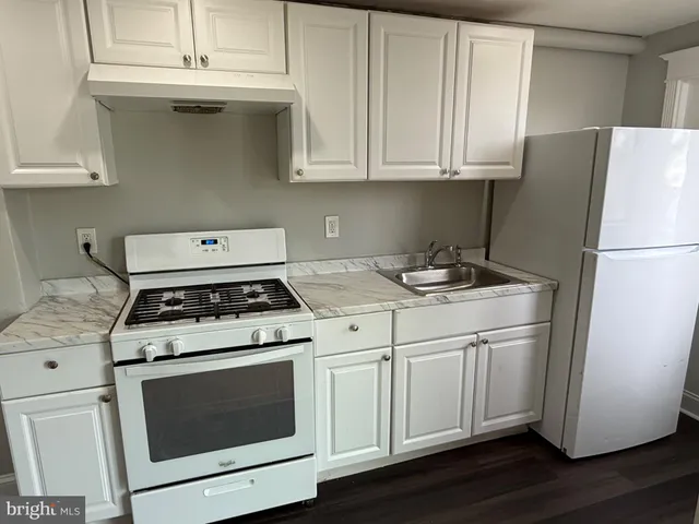 a kitchen with a stove cabinets and wooden floor