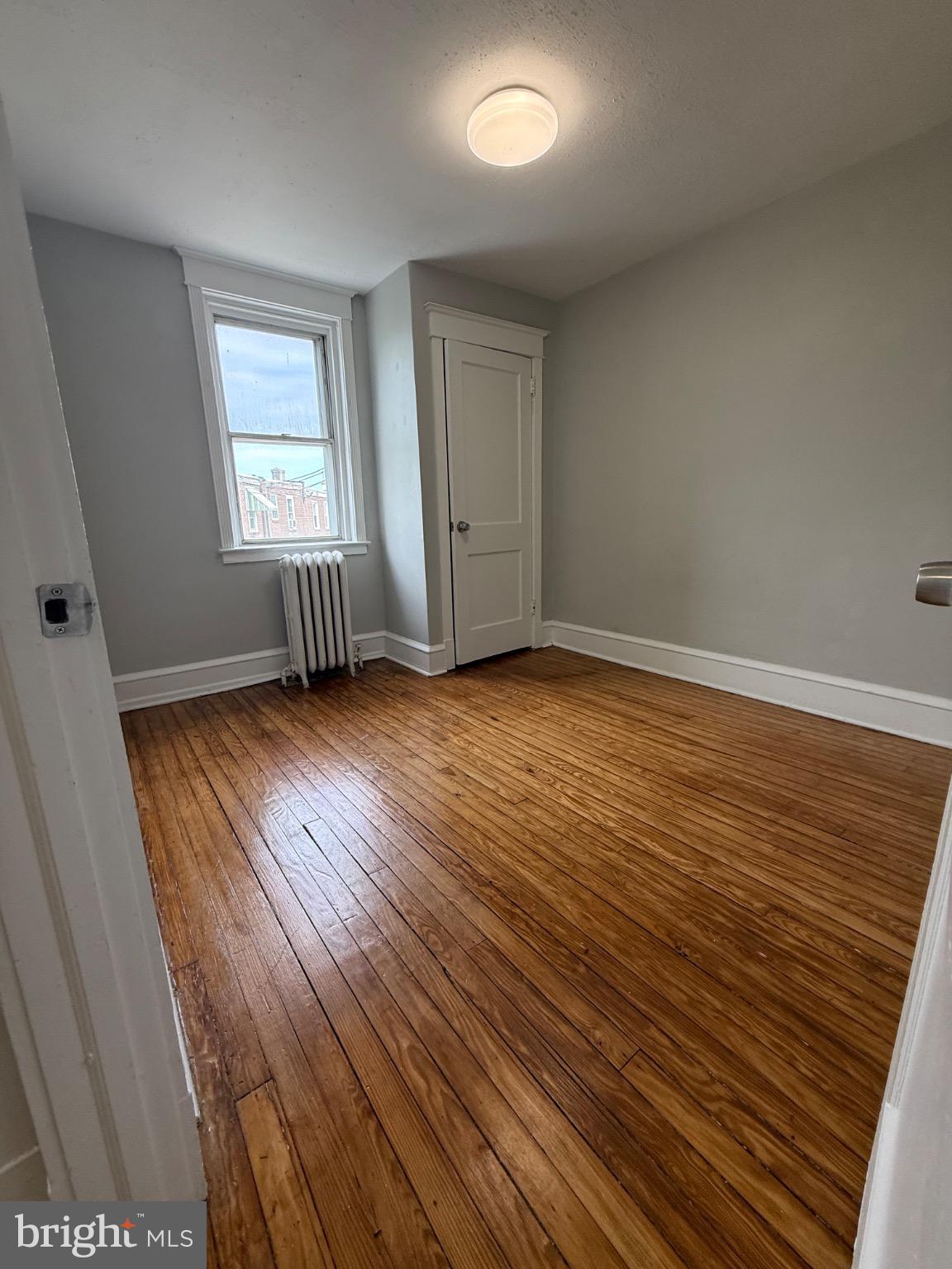 607 Littlecroft Road Upper Darby, PA 19082 - Photo 15 of 34 an empty room with wooden floor and windows