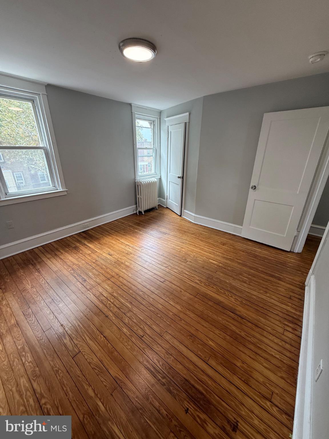 607 Littlecroft Road Upper Darby, PA 19082 - Photo 20 of 34 an empty room with wooden floor and windows
