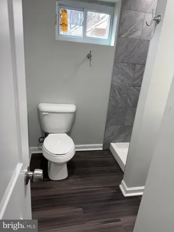 a white toilet sitting next to a small window