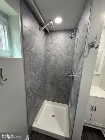 a bathroom with a tub shower vanity and a sink