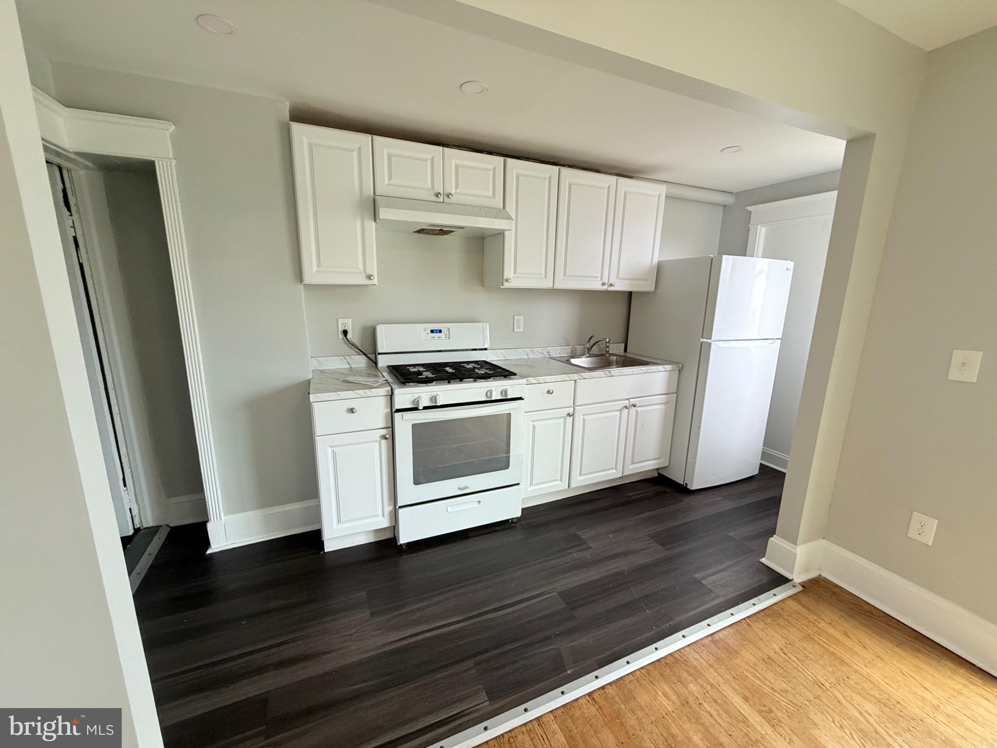 607 Littlecroft Road Upper Darby, PA 19082 - Photo 8 of 34 a kitchen with white cabinets and a wooden floor