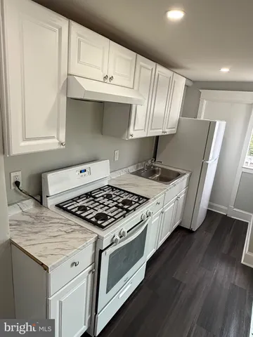 a kitchen with granite countertop a stove and a sink