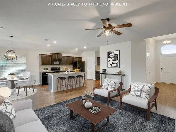 a living room with furniture kitchen view and a wooden floor