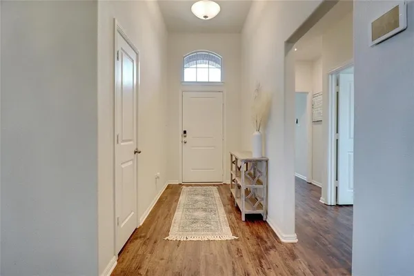 a view of a hallway with wooden floor and a bathroom