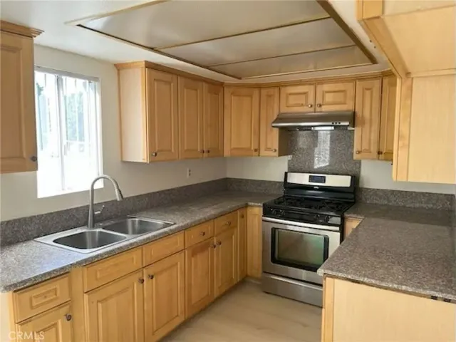a kitchen with a sink stove and cabinets