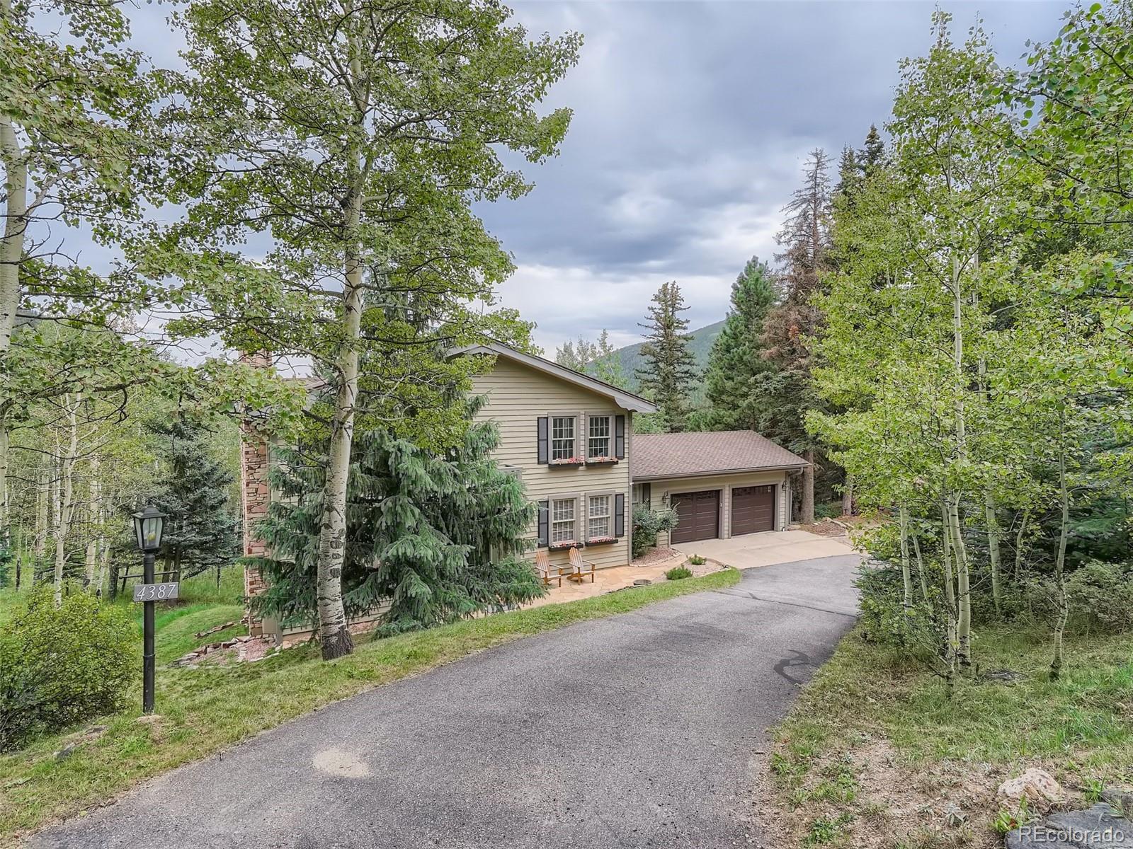 4387 Witter Gulch Road Evergreen, CO 80439 - Photo 1 of 31 a view of a yard in front of house
