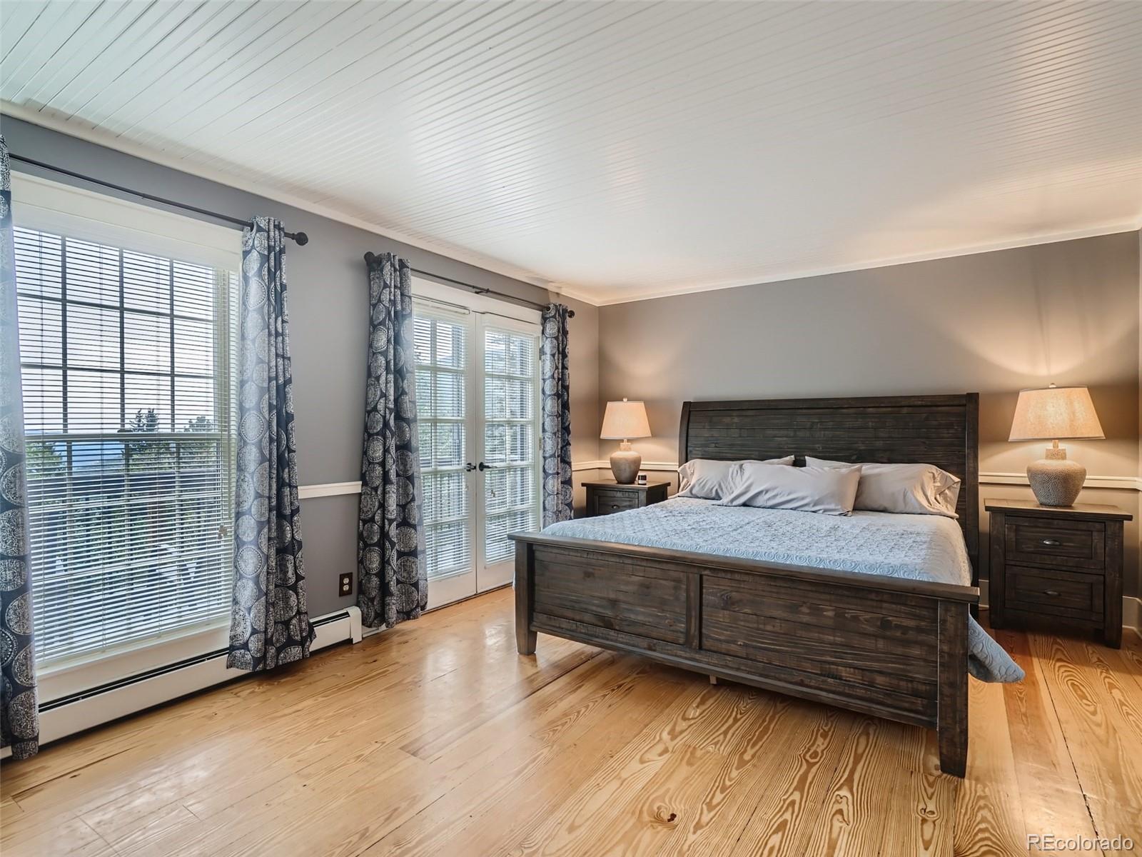 4387 Witter Gulch Road Evergreen, CO 80439 - Photo 11 of 31 a bedroom with a bed and wooden floor