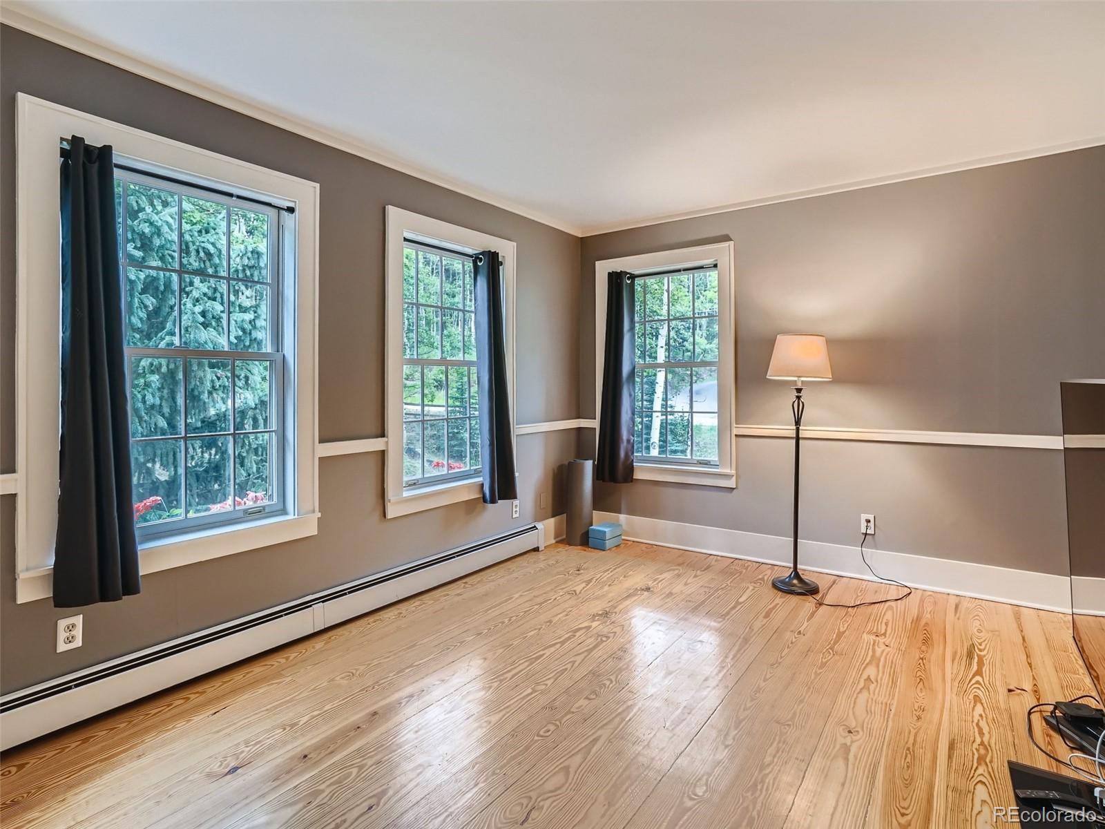 4387 Witter Gulch Road Evergreen, CO 80439 - Photo 12 of 31 a view of an empty room with wooden floor and a window