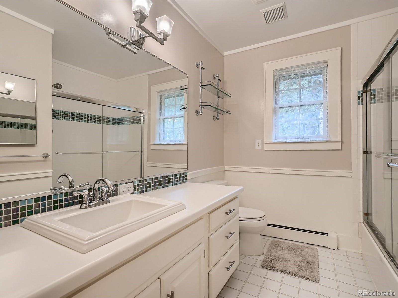 4387 Witter Gulch Road Evergreen, CO 80439 - Photo 15 of 31 a bathroom with a sink a toilet a mirror and shower