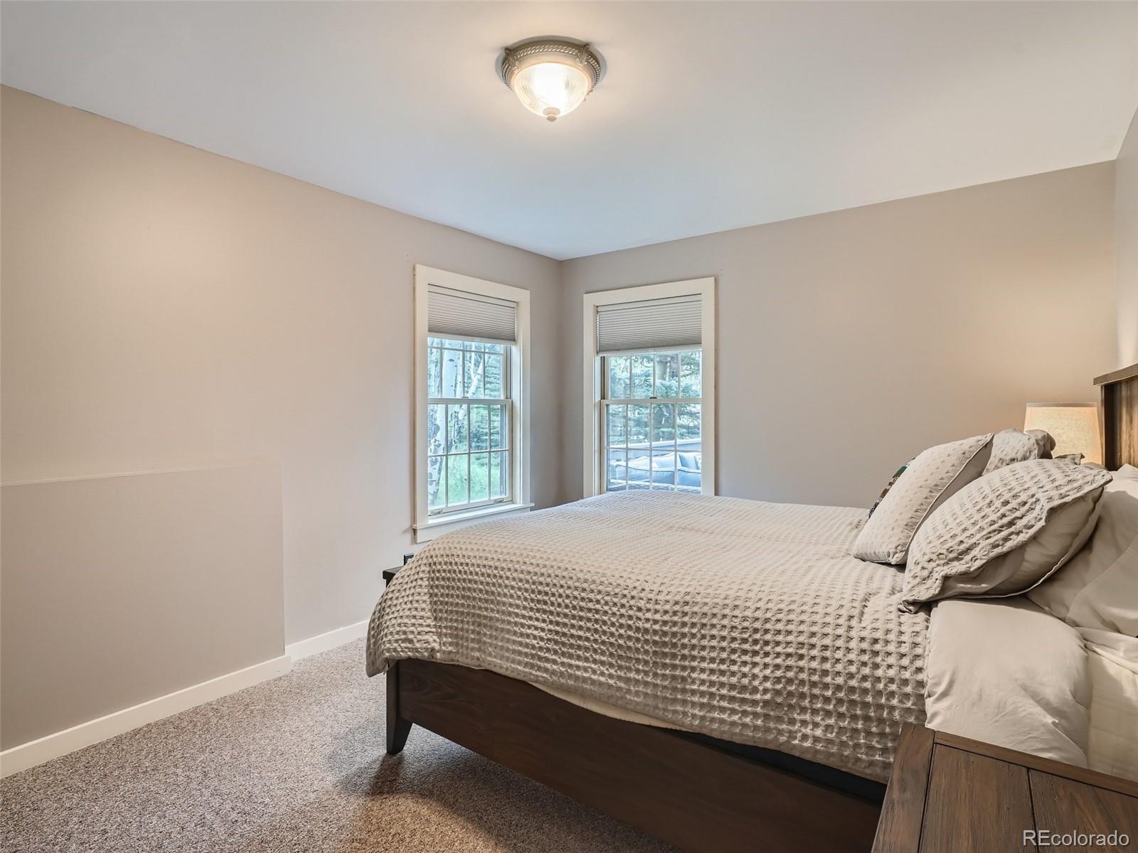 4387 Witter Gulch Road Evergreen, CO 80439 - Photo 20 of 31 a bedroom with a bed and a window