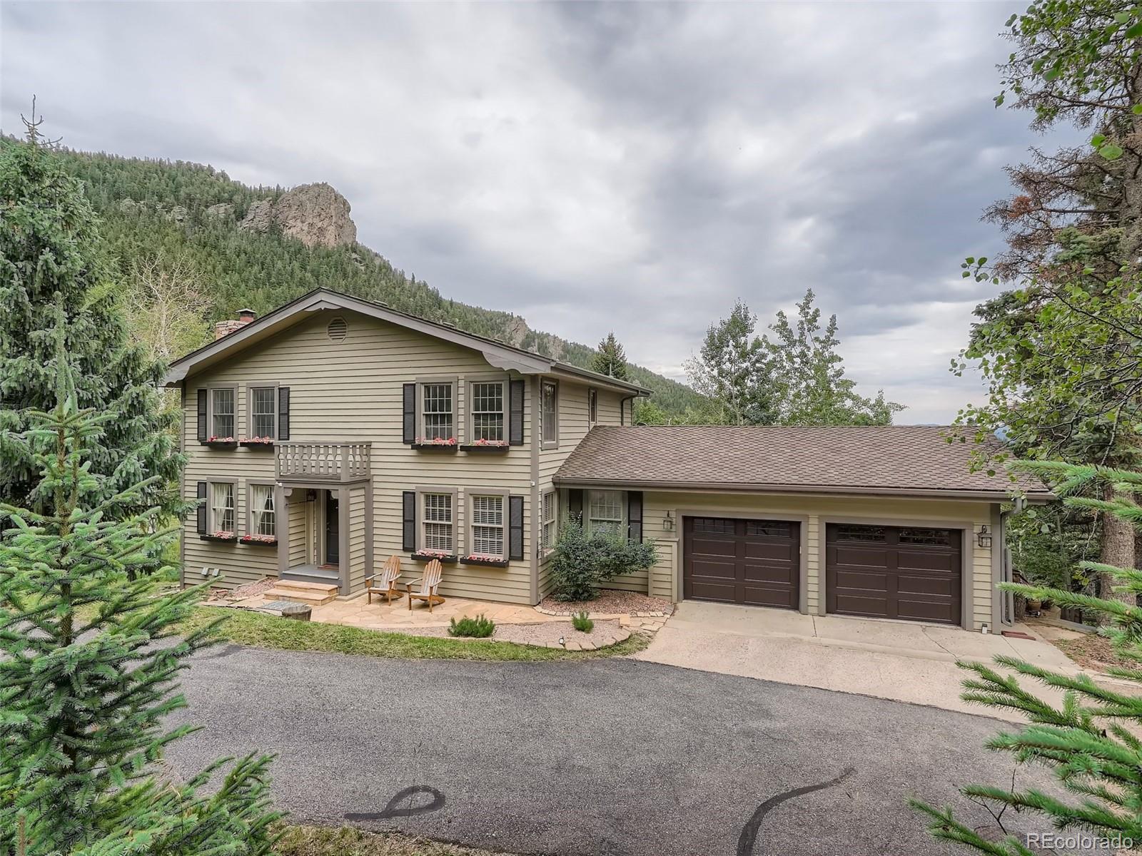 4387 Witter Gulch Road Evergreen, CO 80439 - Photo 2 of 31 a front view of a house with garden