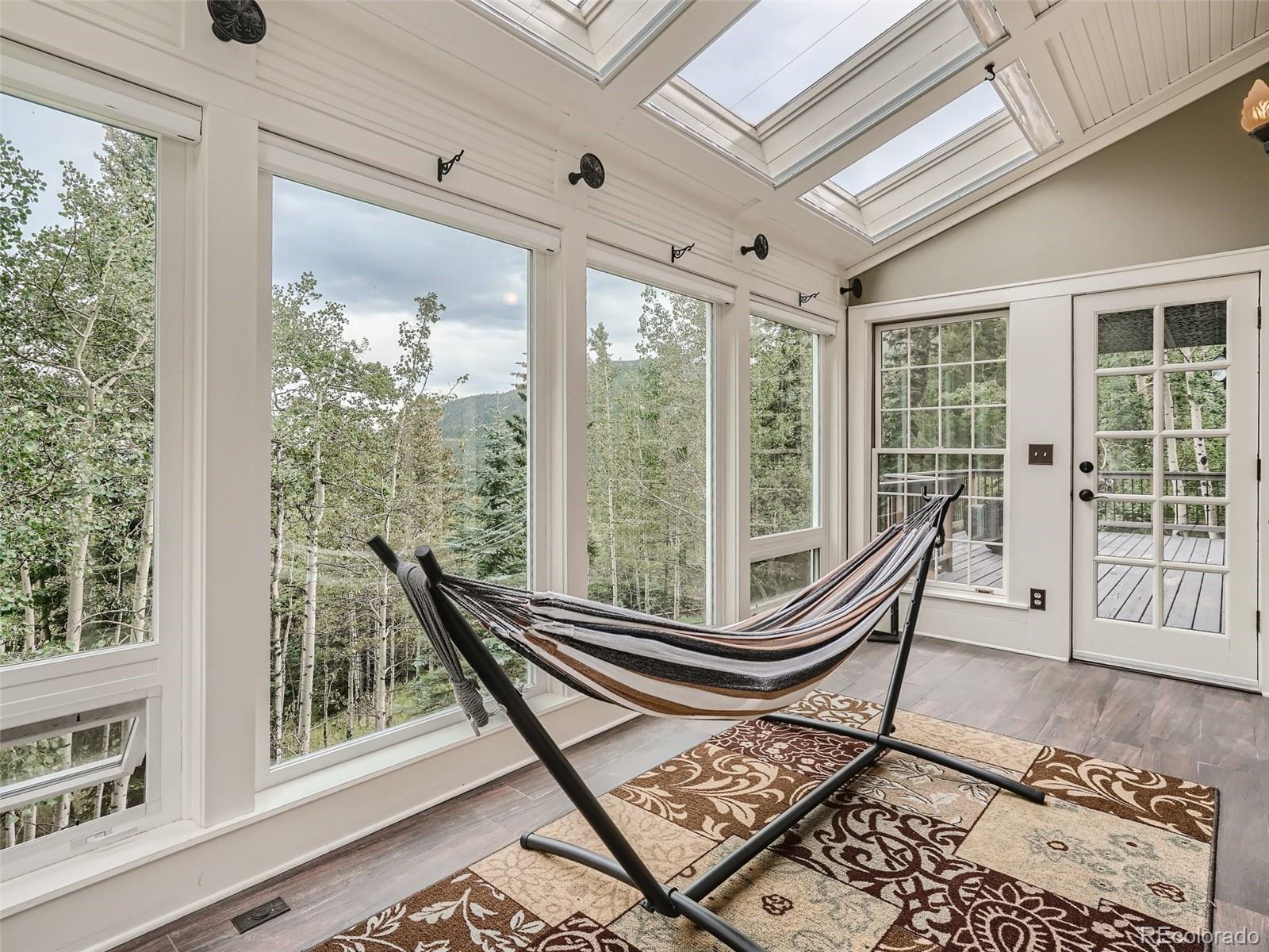 4387 Witter Gulch Road Evergreen, CO 80439 - Photo 24 of 31 a living room with a large windows and a table