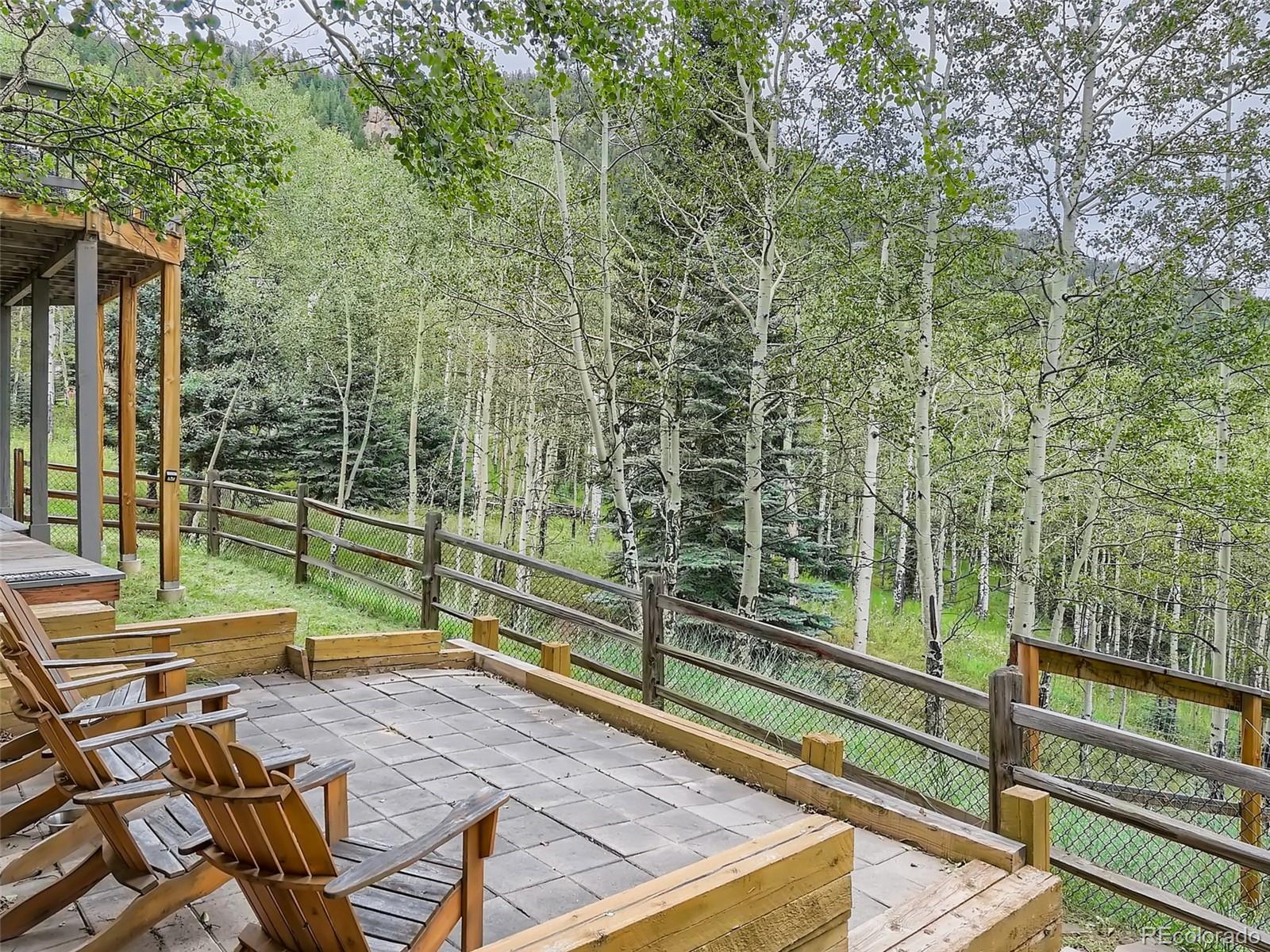 4387 Witter Gulch Road Evergreen, CO 80439 - Photo 26 of 31 a view of a yard with wooden fence and a bench
