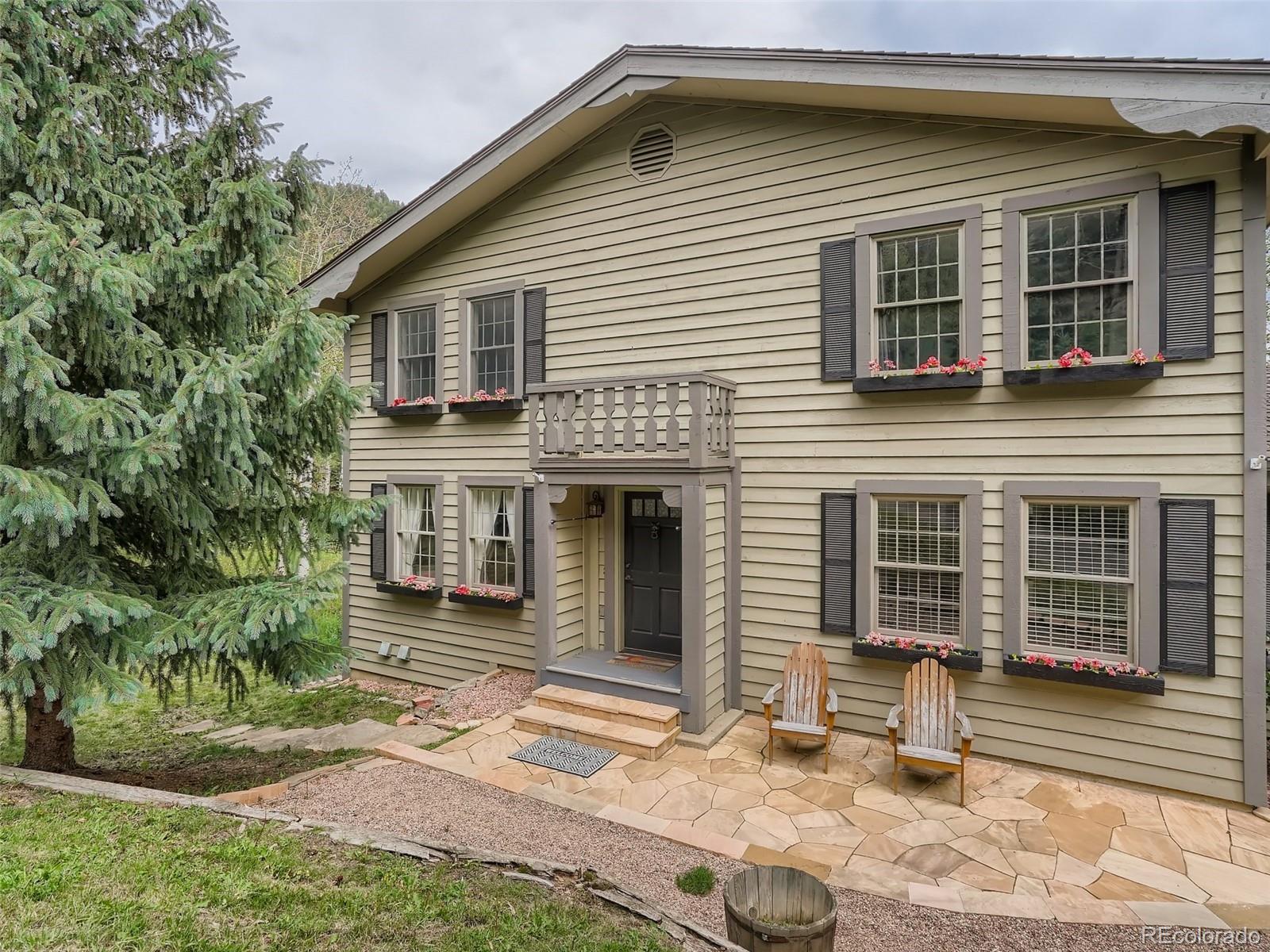 4387 Witter Gulch Road Evergreen, CO 80439 - Photo 3 of 31 a front view of a house with a yard