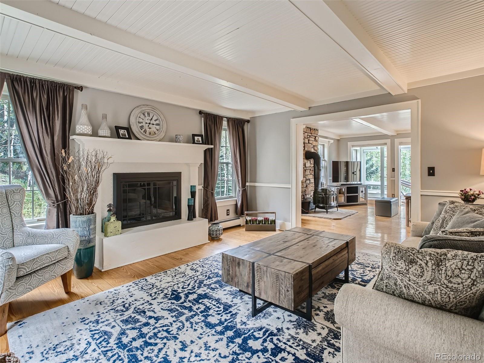 4387 Witter Gulch Road Evergreen, CO 80439 - Photo 4 of 31 a living room with furniture and a fireplace