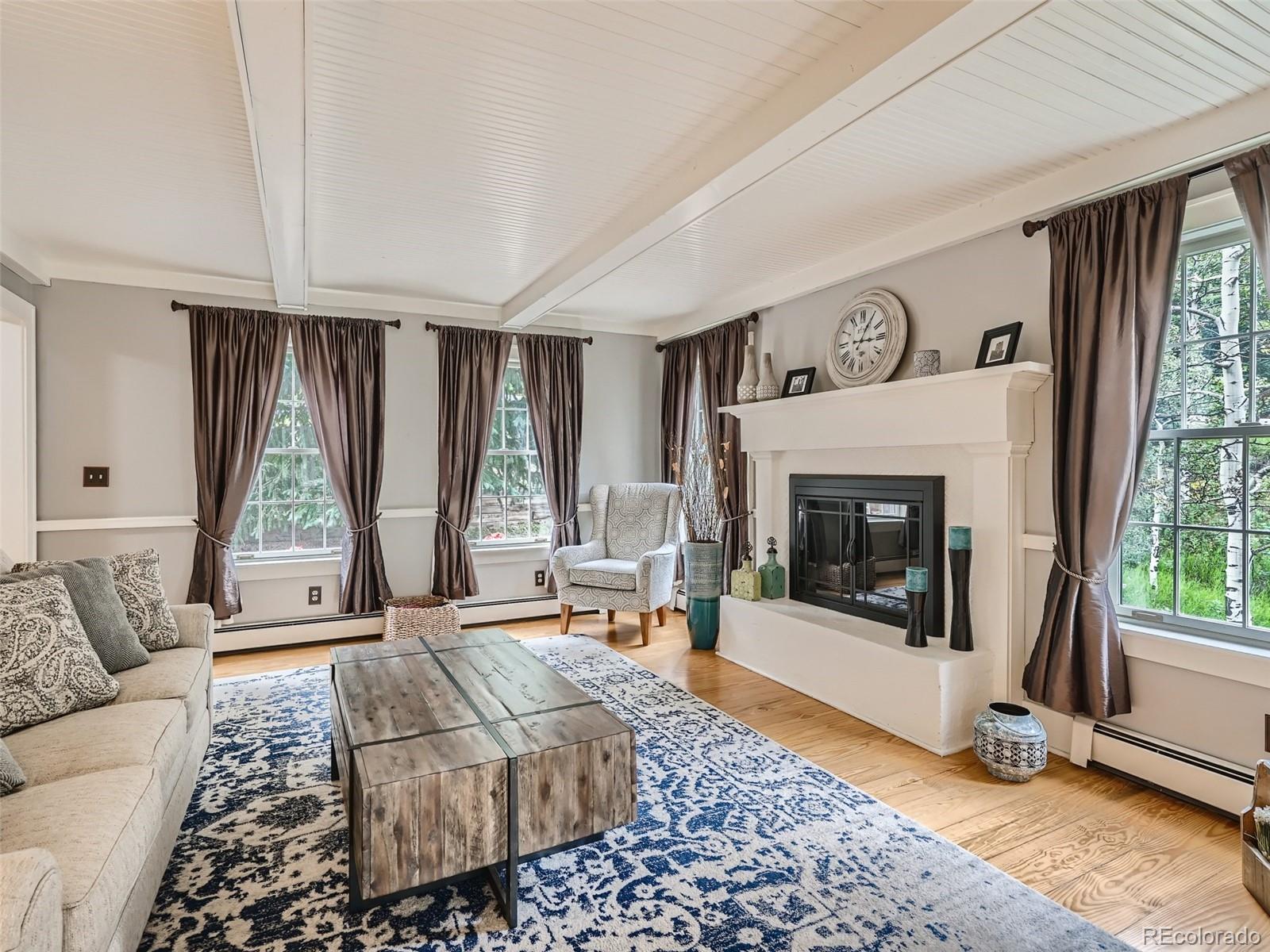 4387 Witter Gulch Road Evergreen, CO 80439 - Photo 5 of 31 a living room with furniture and a fireplace