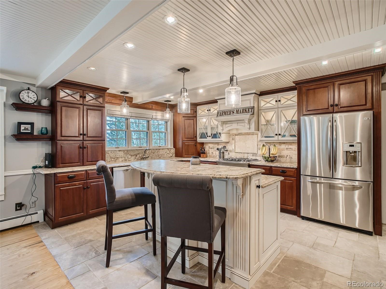 4387 Witter Gulch Road Evergreen, CO 80439 - Photo 7 of 31 a kitchen with stainless steel appliances granite countertop a refrigerator a sink dishwasher a dining table and chairs with wooden floor