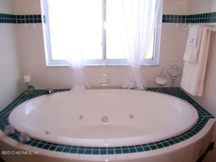516 Moultrie Wells Road St. Augustine, FL 32086 - Photo 12 of 18 a bathroom with a tub and mirror