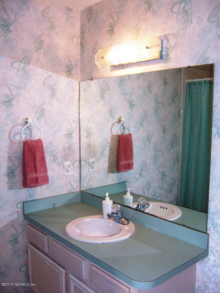 516 Moultrie Wells Road St. Augustine, FL 32086 - Photo 14 of 18 a bathroom with a granite countertop sink and a mirror