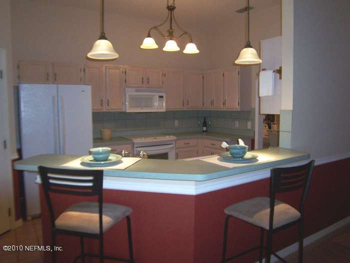 516 Moultrie Wells Road St. Augustine, FL 32086 - Photo 6 of 18 a kitchen with a table chairs and a chandelier
