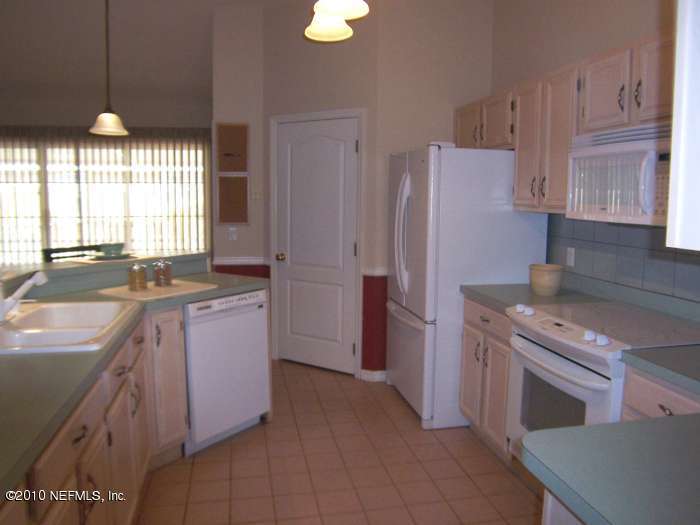 516 Moultrie Wells Road St. Augustine, FL 32086 - Photo 9 of 18 a kitchen with a sink stove and refrigerator