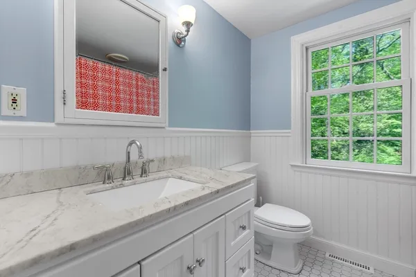 a bathroom with a granite countertop toilet sink and mirror