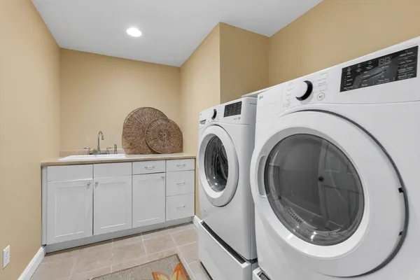 a utility room with sink dryer and washer