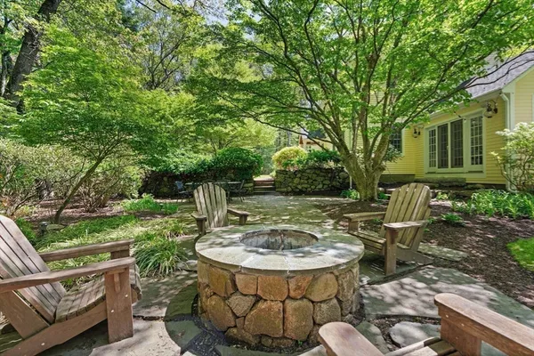 a view of a chair and table in backyard of the house