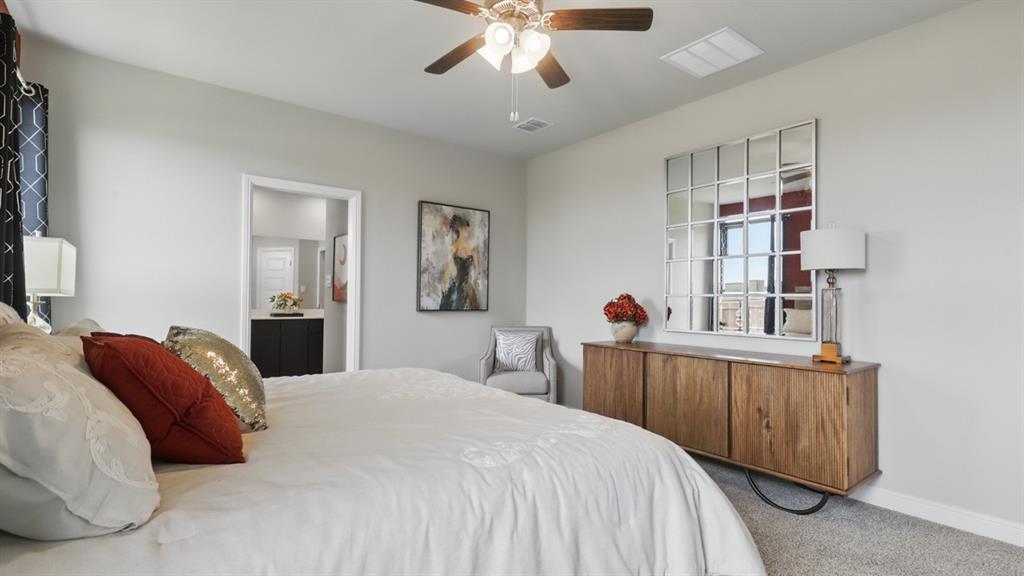 1922 Jackson Street Cleburne, TX 76033 - Photo 16 of 39 a bedroom with a large bed and a chandelier