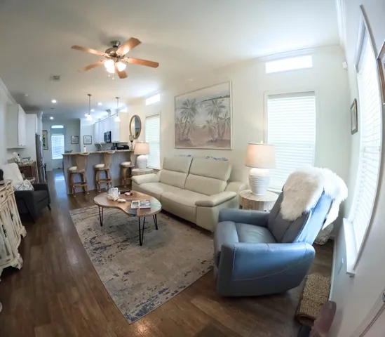 a living room with furniture kitchen view and a chandelier