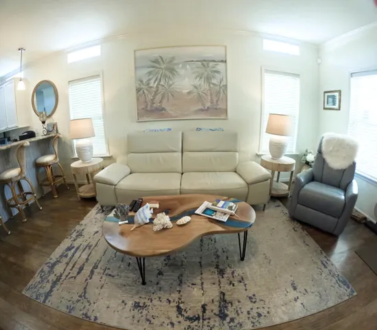 a living room with furniture a rug a lamp and a window